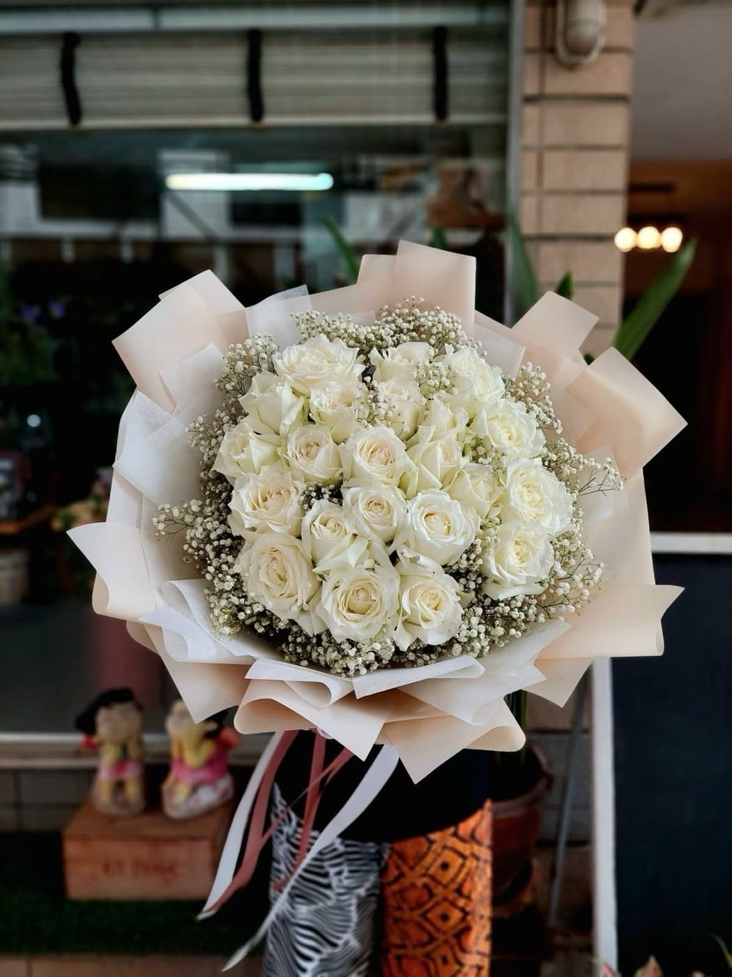 White roses and baby's breath in cream wrap